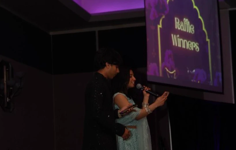 Pranav and a co-host presenting on stage at UCF Diwali
